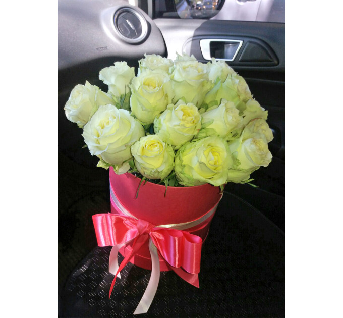 білі троянди у капелюшної коробці